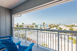 een balkon met blauwe stoelen en uitzicht op het strand bij The J Hotel Dunedin Clearwater, an Ascend Collection Hotel in Dunedin