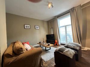 a living room with a couch and a table at La Tete dans les Etoiles appartement in Durbuy +3 photos
