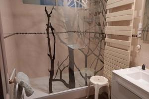 Un baño con ducha con una cortina de ducha de árbol. en Villa Lutetia, en Le Mont-Dore