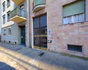 a brick building with a yellow door on a street at San Paolo Apartment in Pisa