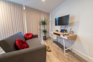 ロンドンにあるLuxury City Escape Apartmentsのソファとテレビ付きの机のあるリビングルーム