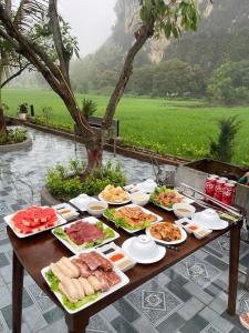 a table with many plates of food on it at Tam Coc Kamili Bungalow & Homestay in Ninh Binh