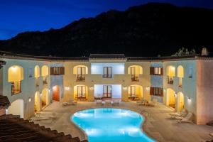 an outdoor swimming pool in front of a building at Hotel Monti Di Mola in Porto Cervo