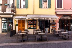 una fila de mesas y sillas frente a un restaurante en La Casa in Paese, en Peschiera del Garda 55 fotos más