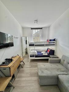 un soggiorno con letto a castello e divano di Willesden Green Rooms a Londra