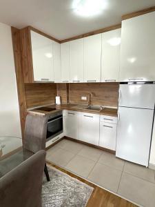 a kitchen with white cabinets and a sink at Apartman River - stan na dan Gradiška in Bosanska Gradiška +10 photos