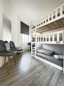 Camera con 2 letti a castello, tavolo e sedie. di Willesden Green Rooms a Londra