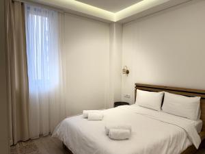 a bedroom with a white bed with two towels on it at Luxury 2-bedroom apartment in the center by Sweet Home in Yerevan