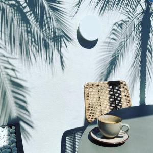 een kopje koffie op een tafel met een palmboom bij PALM HOUSE apartment in Tarifa