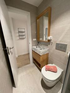 een badkamer met een toilet, een wastafel en een spiegel bij PALM HOUSE apartment in Tarifa +4 foto's