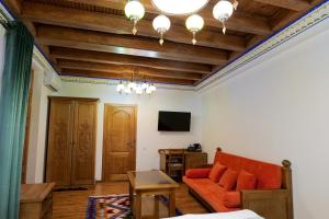 a living room with a couch and a tv at Istat Boutique Hotel in Bukhara