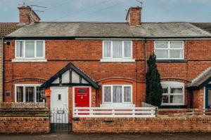 a red brick house with a red door at Modern 3 bed perfect for contractors and families in Maltby
