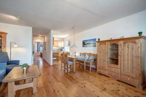Haus Rolandseck - FeWo 03 في بانسين: غرفة معيشة مع أريكة زرقاء وطاولة