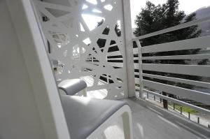 a white railing on a balcony with a chair at Lux Home & Garden in Lago