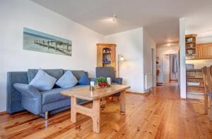 Haus Rolandseck - FeWo 03 في بانسين: غرفة معيشة مع أريكة زرقاء وطاولة
