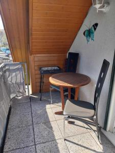 a table and a chair and a butterfly on the wall at Ferienwohnung Hartmann in Wernigerode
