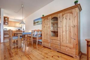 a kitchen and dining room with a large wooden cabinet at Haus Rolandseck - FeWo 03 in Bansin