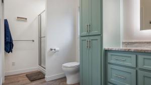 a bathroom with a green cabinet and a toilet at Cree Bay Cabin in Breezy Point