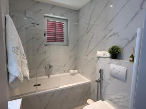 a bathroom with a shower and a tub and a sink at Apartments Plazs 41 in Sukošan +90 photos
