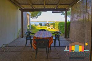 a table and chairs on a patio with a view of the ocean at Fiordo Corallo in Isola Albarella