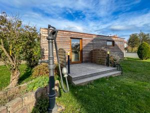 塞尔奈Elsass Tiny House的一座小房子,在院子里设有木门廊