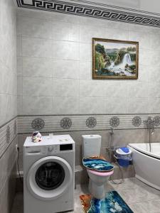 a bathroom with a washing machine and a toilet at Bonushka 5 in Uzbankinty +43 photos
