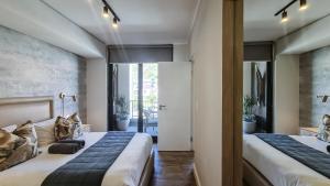 a bedroom with two beds and a hallway with plants at Urban Cliffs - Mossel Cove Unit 208 in Mossel Bay +18 photos