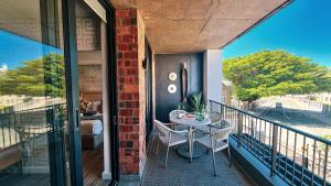 a balcony with a table and chairs on it at Urban Cliffs - Mossel Cove Unit 208 in Mossel Bay