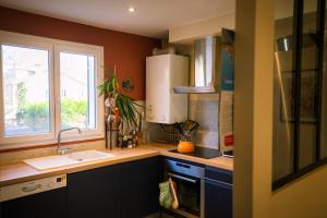 una cucina con un lavandino e una finestra di La Maison Raspail - Calme Disney RER A a Neuilly-Plaisance