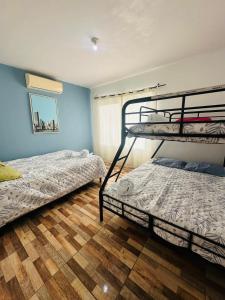 two bunk beds in a room with blue walls at Sol y Arena Casa Iztapa in El Conacaste