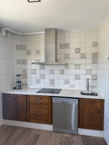 a kitchen with a sink and a dishwasher at Apartamentos Bolonia - M a n u e l a in Bolonia