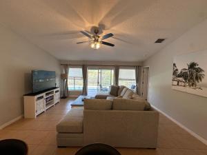 ein Wohnzimmer mit einer Couch und einem Deckenventilator in der Unterkunft Charming Villa with Private Pool 20 min to Disney! in Davenport