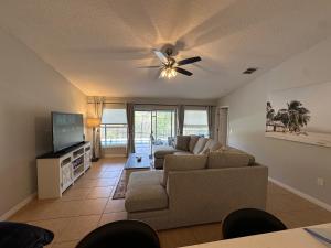 ein Wohnzimmer mit einer Couch und einem Deckenventilator in der Unterkunft Charming Villa with Private Pool 20 min to Disney! in Davenport