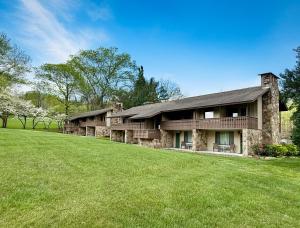 a large house with a grass field in front of it at The Parkman Great Smoky Mountains - Cades Cove in Townsend