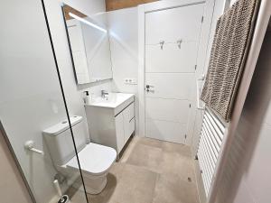 a white bathroom with a toilet and a sink at Via de la Plata Luxury Suites 2C in La Bañeza