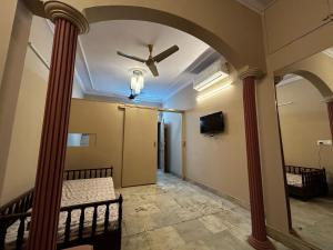 a hallway with a ceiling fan and columns at SREA Homestead Dormitory in New Delhi