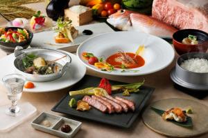 a table with plates of food and bowls of food at Courtyard by Marriott Shin-Osaka Station in Osaka