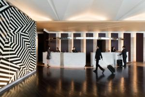 a group of people walking through a lobby with luggage at Courtyard by Marriott Shin-Osaka Station in Osaka