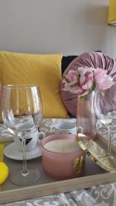 a tray with a table with glasses and a candle at Elite Home 5 Jeżyce- Barańczaka 5 in Poznań