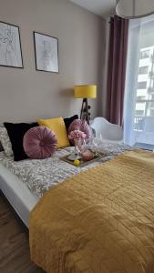 a bed with a table with flowers on it at Elite Home 5 Jeżyce- Barańczaka 5 in Poznań +21 photos