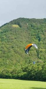 a person flying a kite in front of a mountain at Le Camus in Belonchamp