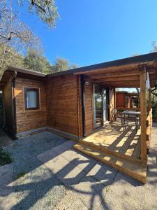 a log cabin with a deck and a patio at Campeggio Gianna Golfo dei Poeti in Lerici