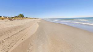 a beach with footprints in the sand and the ocean at Unit 109 -1br Apt Oceanfront Complex With Pool in Cocoa Beach
