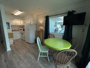 a small kitchen with a green table and chairs at Unit 109 -1br Apt Oceanfront Complex With Pool in Cocoa Beach
