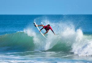 a man riding a wave on a surfboard in the ocean at Unit 109 -1br Apt Oceanfront Complex With Pool in Cocoa Beach