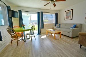 a living room with a table and chairs and a couch at Unit 109 -1br Apt Oceanfront Complex With Pool in Cocoa Beach