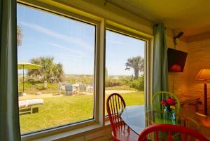 ein Esszimmer mit einem Glastisch und einem Fenster in der Unterkunft Unit 119 Direct Oceanfront Views 2br Heated Pool in Cocoa Beach