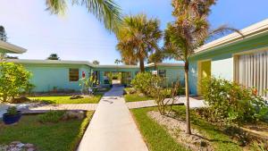 a house with palm trees in front of it at Unit 109 -1br Apt Oceanfront Complex With Pool in Cocoa Beach