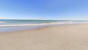 a sandy beach with the ocean in the background at Unit 109 -1br Apt Oceanfront Complex With Pool in Cocoa Beach