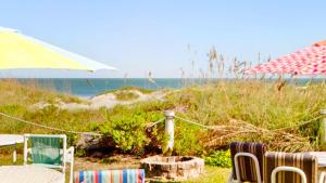 a group of chairs and an umbrella on a beach at Unit 109 -1br Apt Oceanfront Complex With Pool in Cocoa Beach